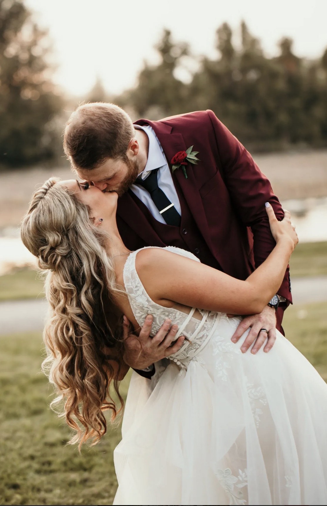 Couple sharing a kiss on the estate grounds at sunset