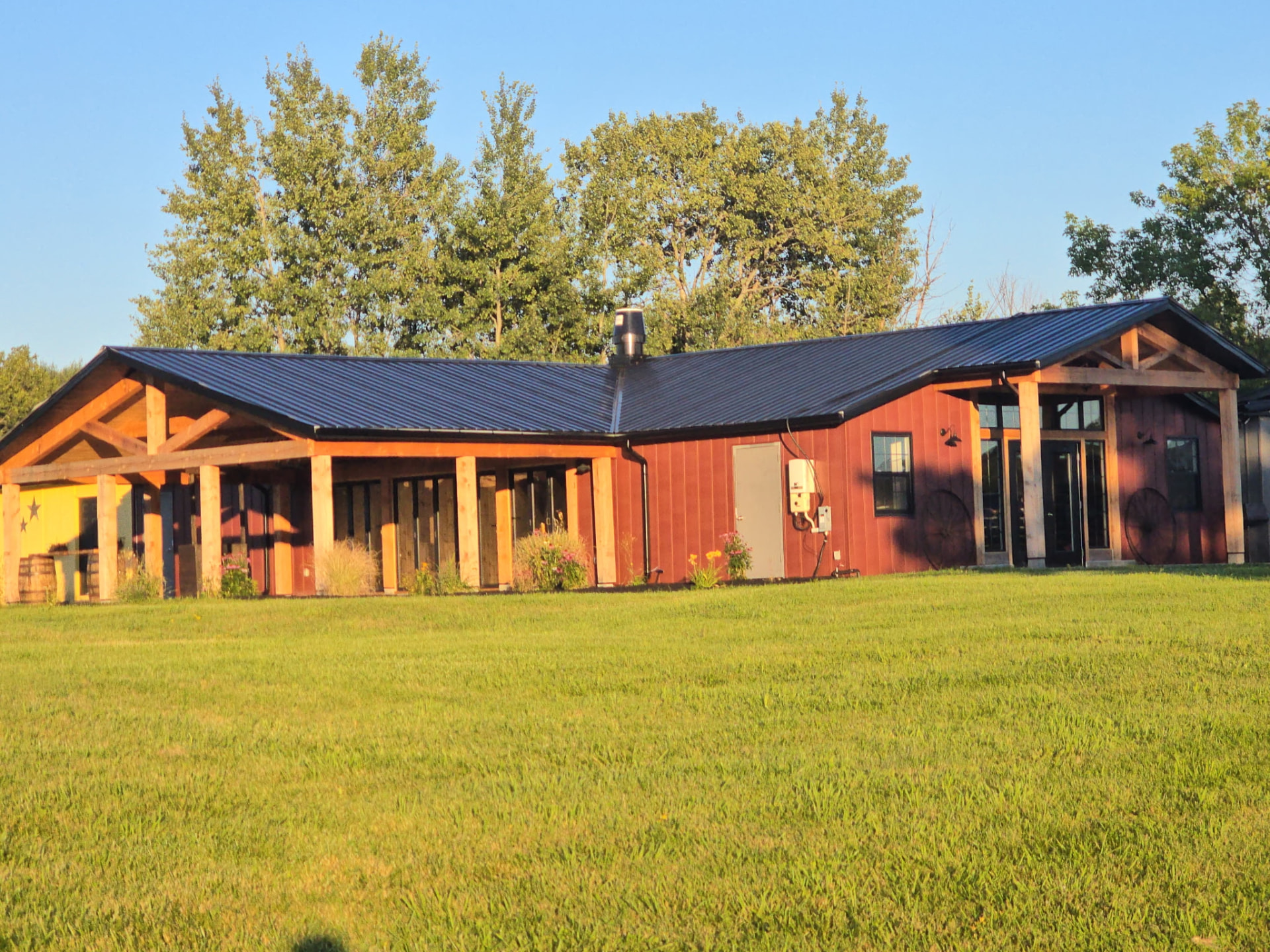 Red timber-frame barn venue across the open lawn in Georgina, Ontario