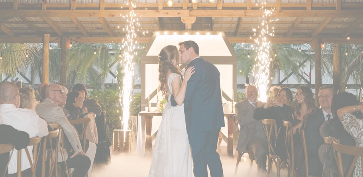 Newlyweds sharing their first dance beneath sparklers at their barn wedding